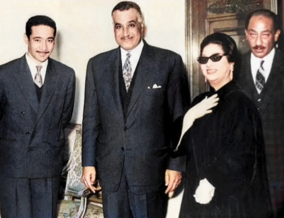 صورة ملونة لأم كلثوم بفستان أسود ونظارة شمسية تقف مع الرئيس جمال عبد الناصر وأنور السادات ورجل آخر.